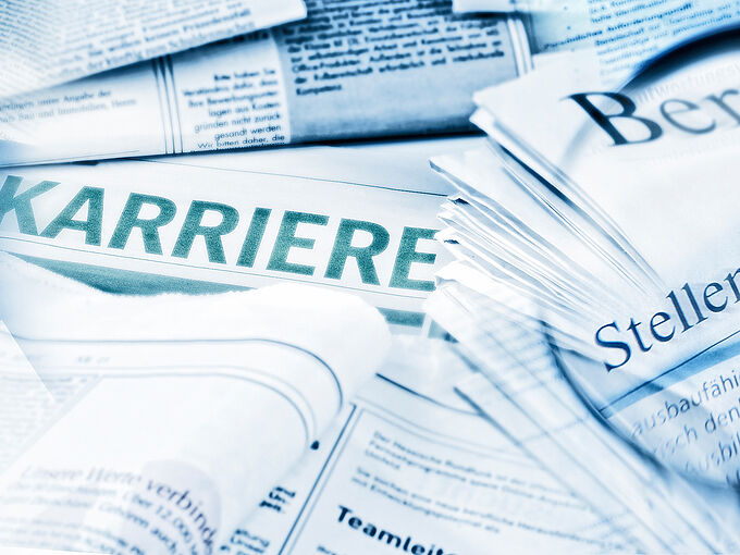 Job offers with magnifying glass and application folder